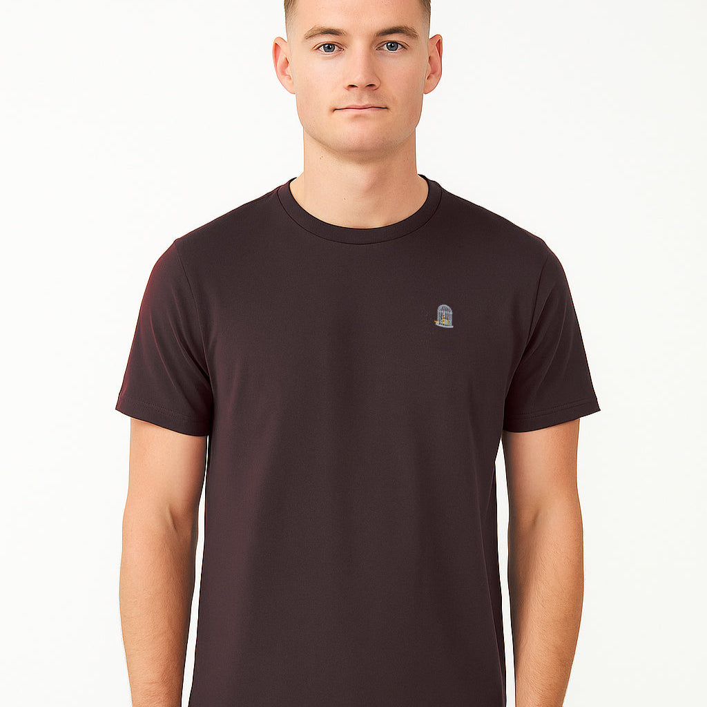 Man wearing a dark brown t-shirt with a small logo on a white background