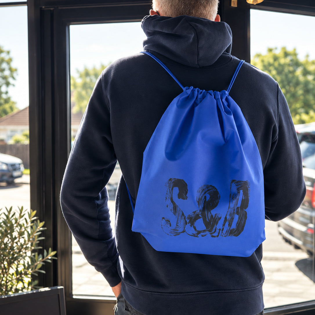 Man wearing the blue S&B drawstring day bag by Sauce & Brown
