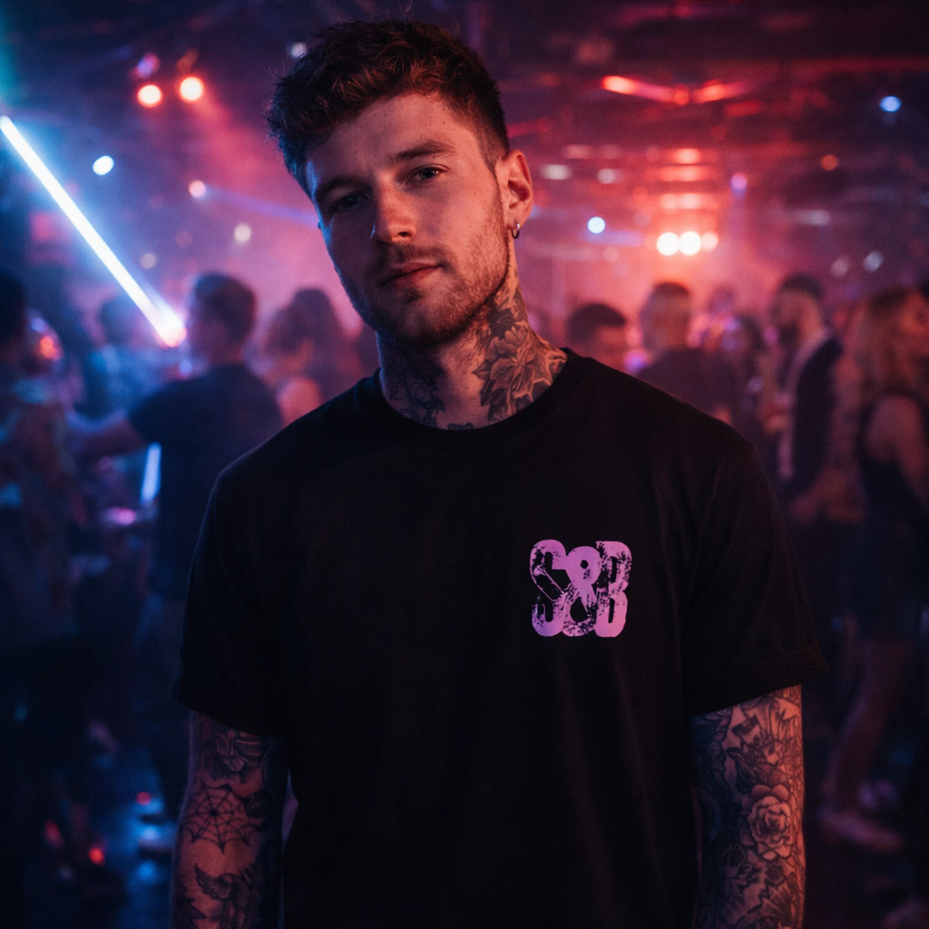 Model wearing Lilac Press Tee in black with lilac logo in nightlife setting by Sauce & Brown