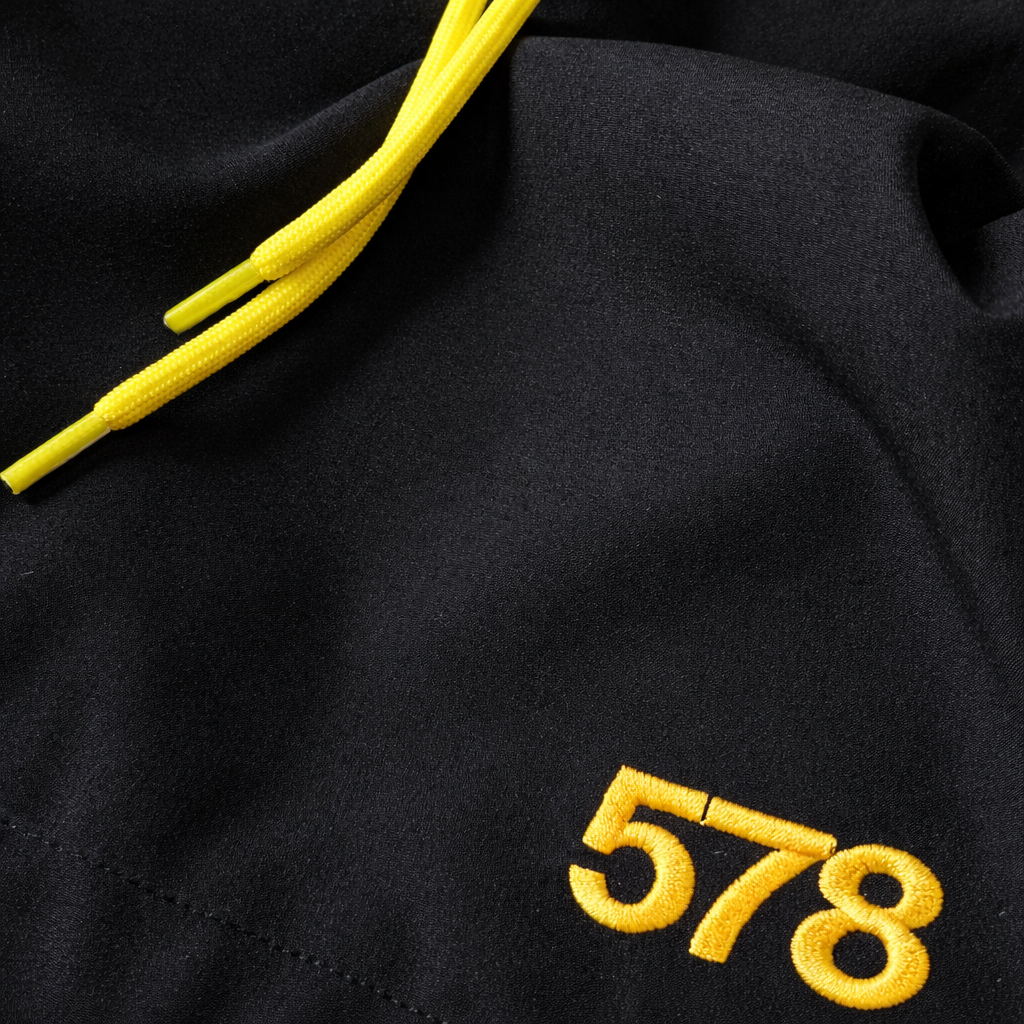Close-up logo detail on Sauce & Brown black swim shorts