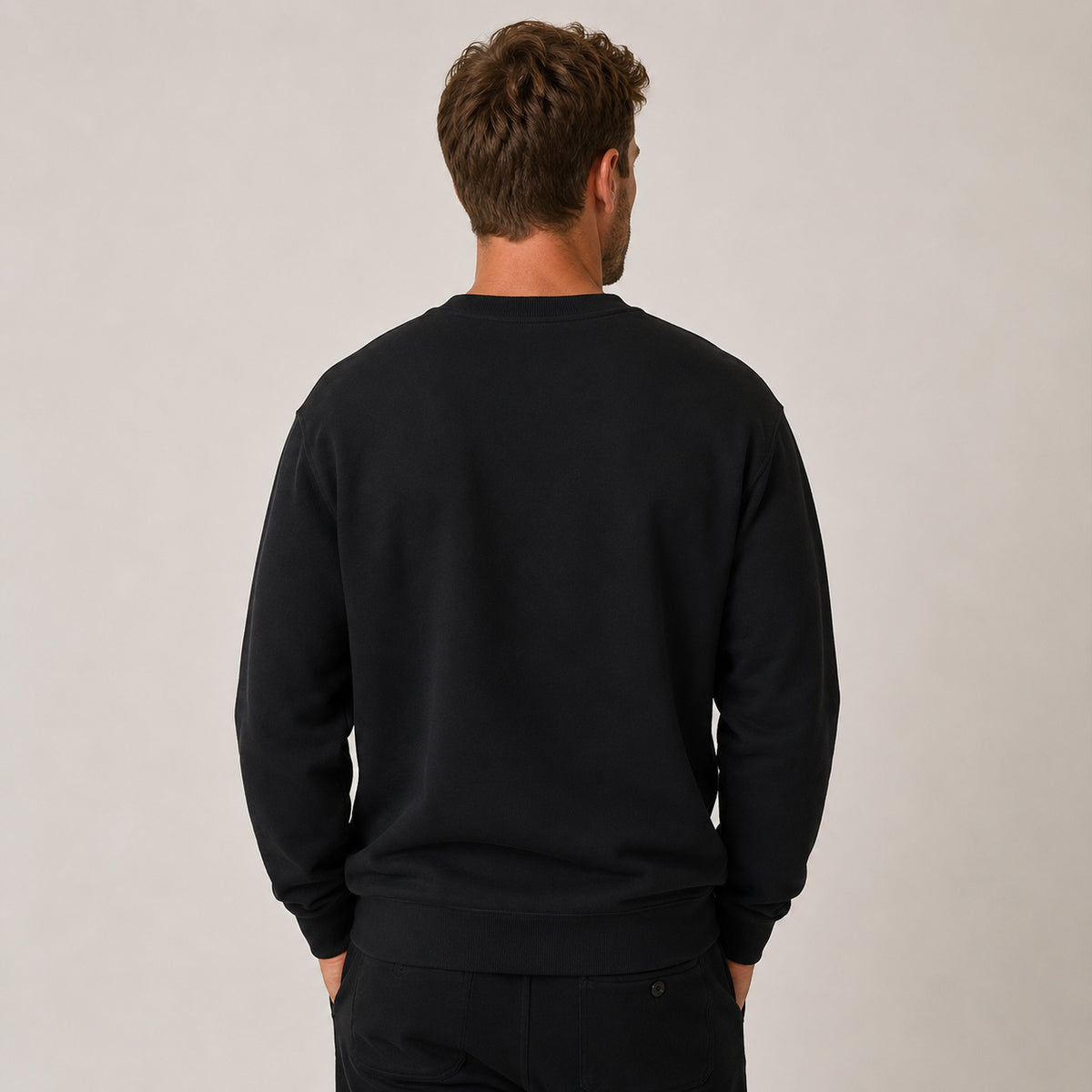 Back view of men’s black organic cotton sweatshirt with relaxed fit and ribbed hem and cuffs