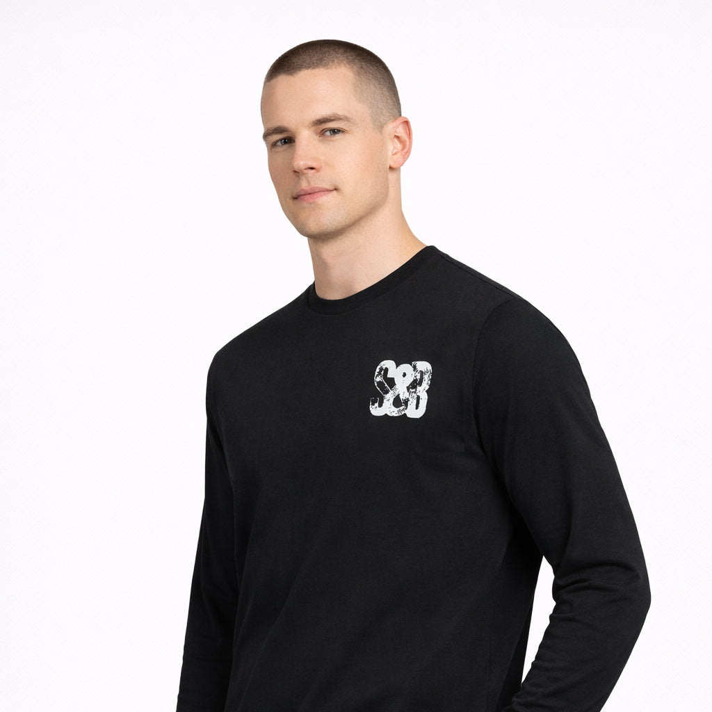 Angled view of Miner Press Long Sleeve Tee in black with logo worn by model by Sauce & Brown