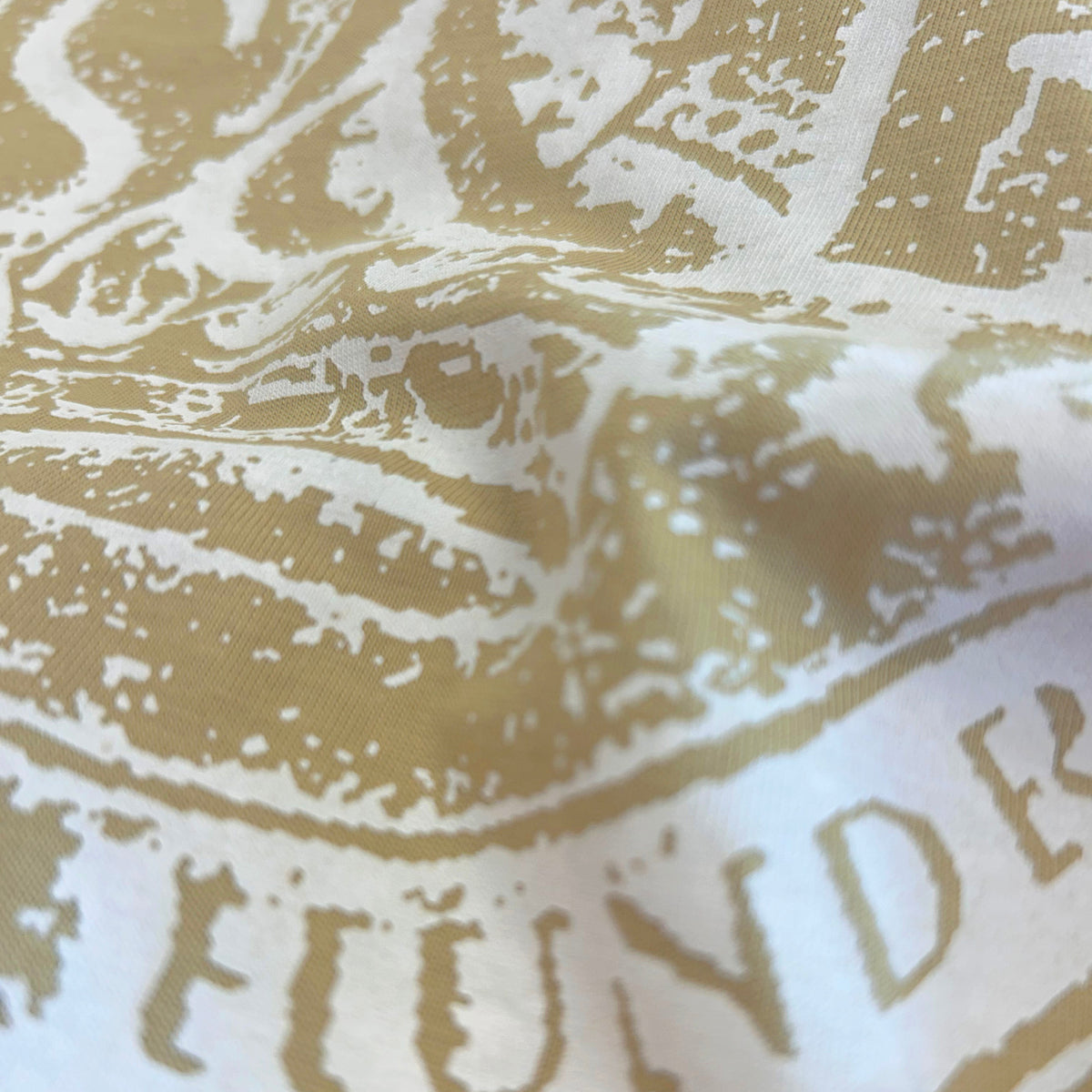 Close-up detail of Sauce & Brown Roots faded olive t-shirt graphic print and cotton fabric texture